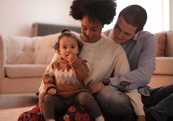 two adults holding a toddler image